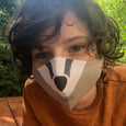 A child wearing a cotton linen badger face mask.